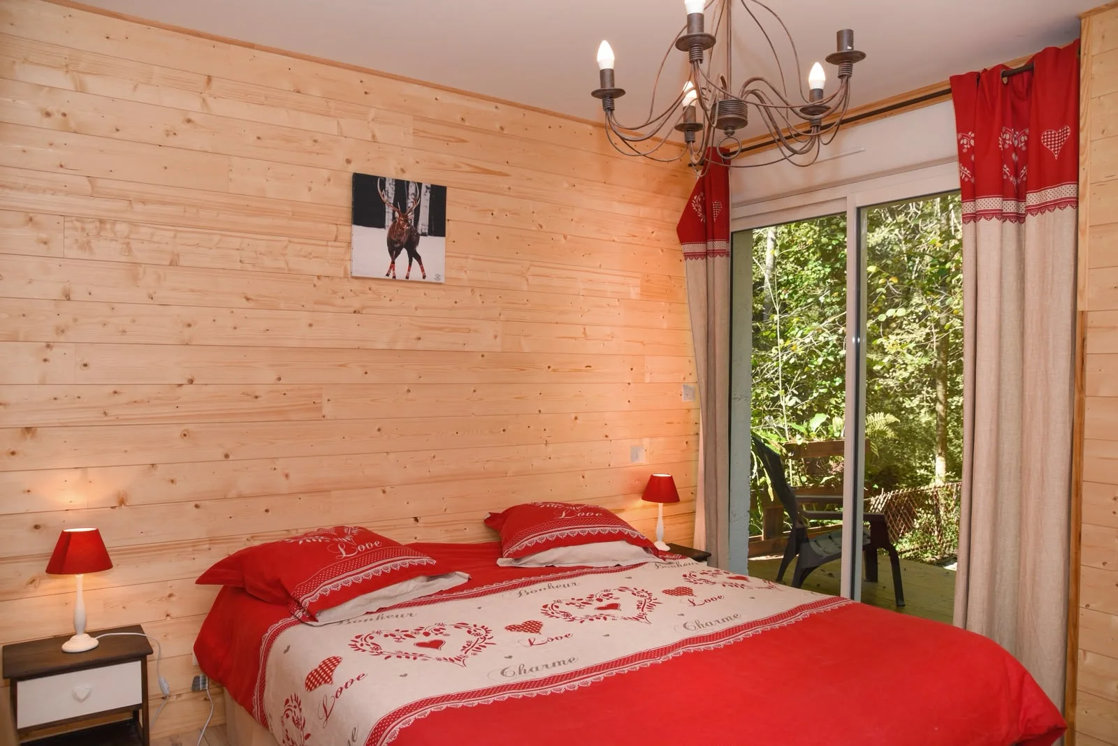 Chambre double en bois donnant sur une petite terrasse forestière